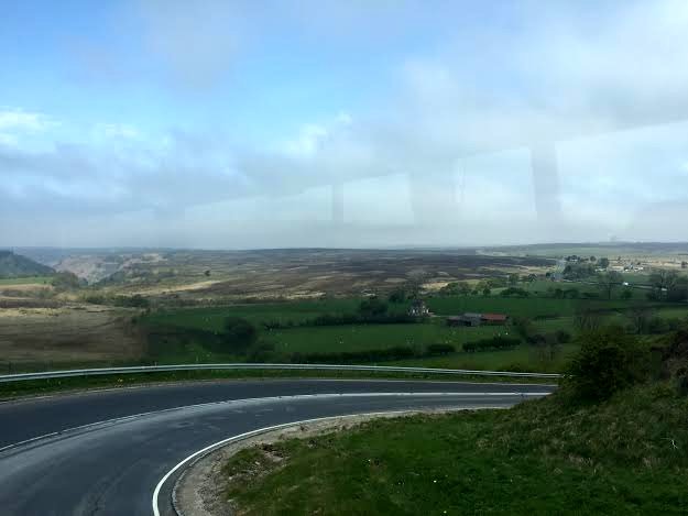 Bild av Devil's Elbow från ett bussfönster med Hole of Horcum i fonden